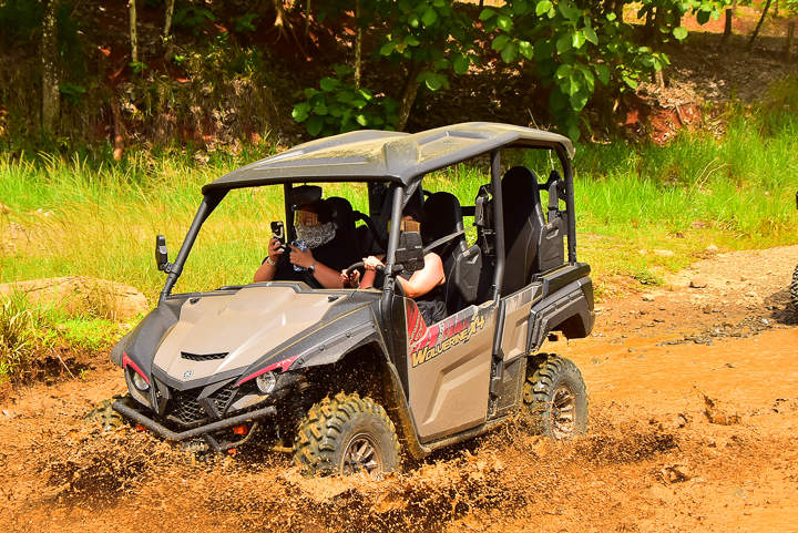 Analys riding in an off-road vehicle splashing through mud during an outdoor adventure